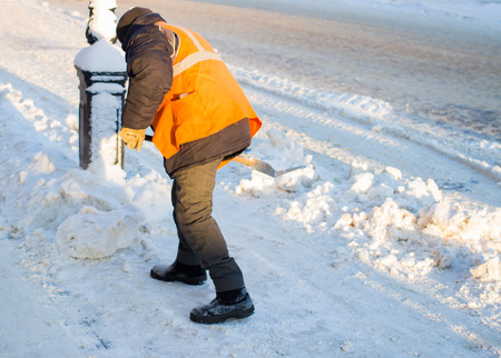 Janitor cleans the street of snow in the morningの写真素材