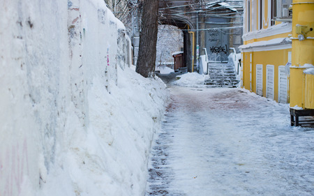 Snow-covered narrow street with arch in the daytimeの写真素材