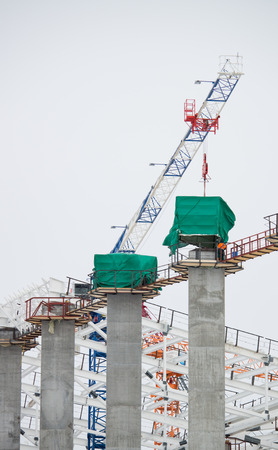 Builders working on the construction of a large building by the dayの写真素材