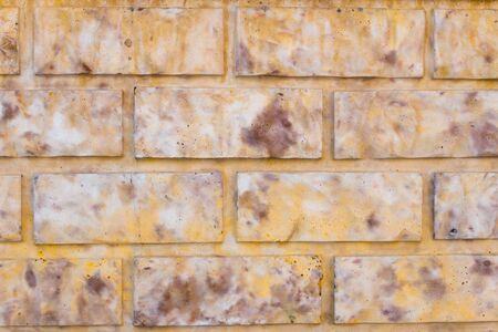 Yellow old brick wall background in the daytimeの写真素材