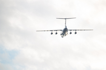 White airplane flying against a white sky background