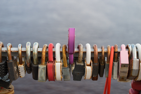 Many locks hang on the background of gray waterの写真素材