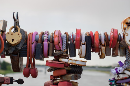 Many locks hang on the background of gray waterの写真素材