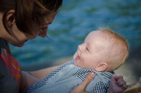 Mother and smiling baby looking to each otherの写真素材