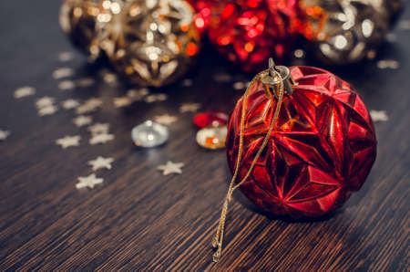 Red christmas ball on bokeh background of xmas ornaments. Merry christmas. Winter holidays. Xmas theme. Happy New Year. Blurred background.の写真素材