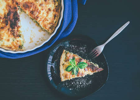 Quiche lorraine pie with chicken, mushrooms and broccoli in blue round baking form on wooden background.の写真素材