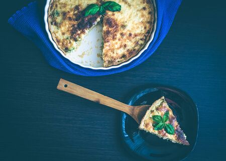 A piece of French quiche Lorraine pie from chicken, mushrooms and broccoli with basilの写真素材