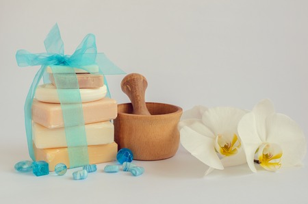 Spa setting in pastel and blue colors with different kind of natural handmade soaps, orchid and the...