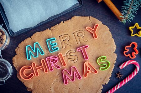 Cutters letters on a dough. Phrase Merry Christmas. Step of making traditional Christmas gingerbread...