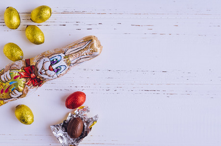 Easter composition with chocolate rabbit and eggs on white shabby chic wooden background with place for text. Copy space.の写真素材