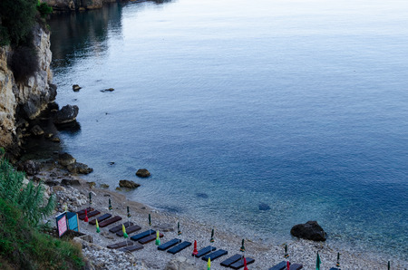 ULCINJ, MONTENEGRO - JULY 30, 2017: Small rock beach Liman on the Adriatic Sea in Ulcinj, Montenegro. Early morning time with empty beach beds, closed umbrellas and without people.のeditorial素材
