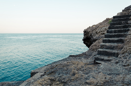 Stone stairs on the rock to the blue sea. Turquoise waters of Adriatic sea with cliffs.の写真素材