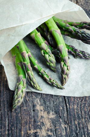 Bunch of fresh organic green asparagus from farm market on an old wooden background with place for text. Healthy food concept. Top view. Copy space.の写真素材