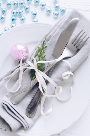 Festive place setting for christmas dinner on white rustic background. Christmas table setting in scandinavian style with natural decorations on wooden table. Holiday Decorations. Top view.の写真素材