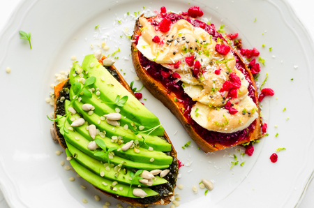 Healthy sandwich on sweet potato for breakfast or snack. One toasts with avocado and other with...