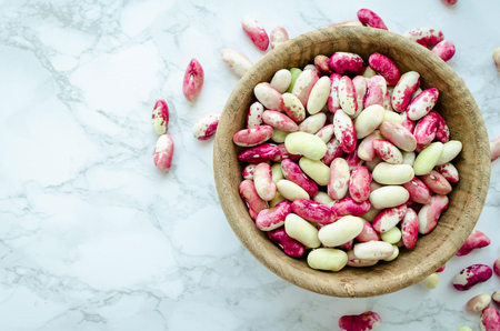 Fresh organic purple grains-beans in wooden bowl on marble table.の写真素材