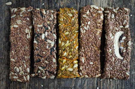 Fitness dietary food. Raw diet bread sticks with flax and sunflower seeds on rustic wooden board.の写真素材