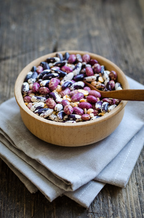 Assortment of dry organic beans and lentils in bowl on rustic wooden table. Variety of raw legumes. Balanced diet, cooking, vegetarian and clean eating concept. Healthy food.の写真素材