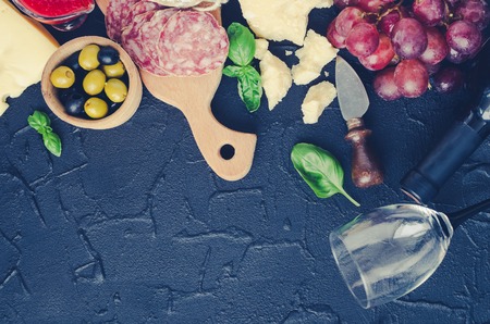 Bottle of wine, corkscrew and antipasti. Table full of mediterranean appetizers or antipasto. Assorted Italian style banquet party food set. Tradition wine tasting concept. Top view. Copy space.の写真素材