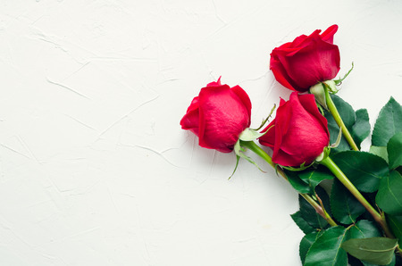 Red roses flowers on white background with place for text. Romantic Valentines holidays concept. Valentine's day greeting card. Copy space. Top view.の写真素材