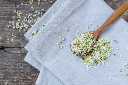 Organic blanched hemp seeds in a spoon on rustic wooden table. Healthy eating supplement. Superfood concept.の写真素材