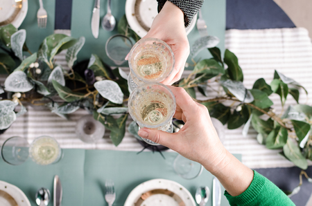 Top view of people eating and toasting with glasses of white wine. Friends or family different ages...