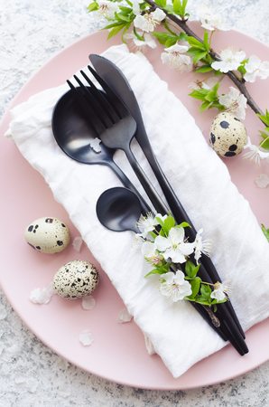Easter table setting with white cherry blossom and cutlery on grey background. Top view. Flat lay.の写真素材