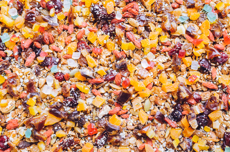 Texture background roasted granola with sesame, pumpkin, sunflower and chia seeds, goji berries, dates and raisins, cranberries, dried apricots, nuts and almonds. Superfood. Top view. Flat lay.の写真素材