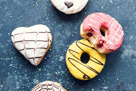 Frosted donuts with bite missing on dark background.の写真素材