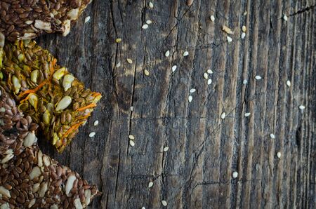 Fitness dietary food. Raw diet breadsticks with flax and sunflower seeds with a mashrooms, carrot or algae on rustic wooden board. Vegan healthy nutrition concept. Top view. Copy space.の写真素材