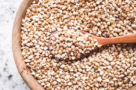 Organic green buckwheat in wooden bowl on greyの写真素材