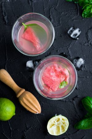 Summer fresh fruit flavored infused water mix of watermelon, lime and basil on black background.の写真素材