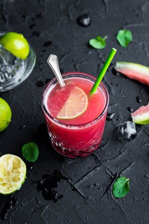 Watermelon drink in glasses with lime and mint on black background.の写真素材