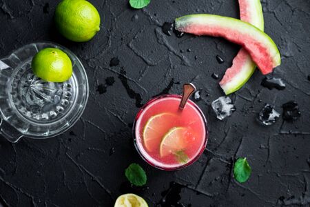 Watermelon drink in glasses with lime and mint on black background.の写真素材
