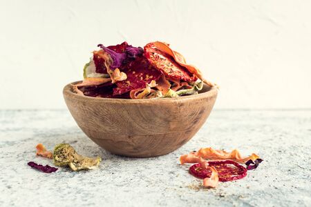 Healthy vegetable homemade chips from beetroot, tomatoes, carrot and zucchini on greyの写真素材