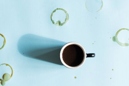 Coffee mug with stains and splashes over blue background. Top view.の写真素材
