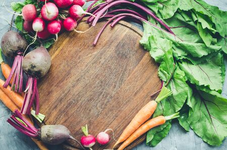 Frame with assorted raw organic vegetables: carrot, beetroot and radish. Healthy clean eating. Different colorful vegetables on wooden board. Top view.の写真素材