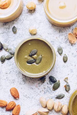 Nuts and seeds butter in jars with ingredients.の写真素材