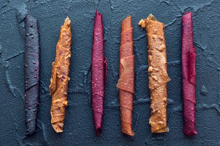 Homemade fruit leather of apple, apricot, strawberry and blueberry on black