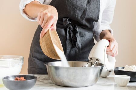 Woman making cake in her kitchen. Step by step recipe of chocolate cherry cake. Series. Baking concept.の写真素材