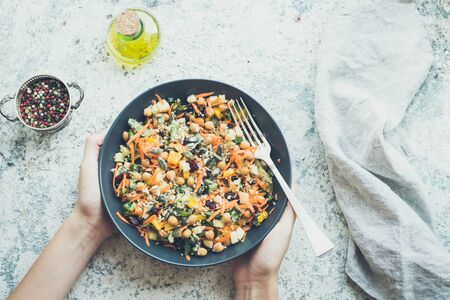 Delicious vegetarian quinoa salad with bell pepper, cucumber, carrot, dried cranberries and pumpkin and sunflower seeds. Healthy eating concept. Top view.の写真素材