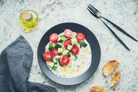 Fresh assorted salad with cucumbers, tomatoes and greek yogurt.の写真素材