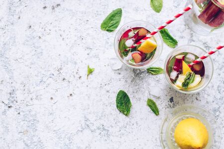Summer refreshing drink with rhubarb, lemon and mint. Rhubarb lemonade. Pitcher with fresh cool spring fruit infused detox water. Health care, fitness, healthy nutrition diet concept. Top view.の写真素材