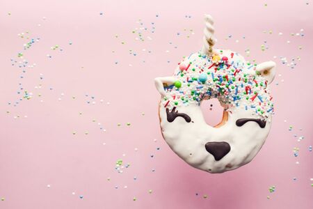 Unicorn donut hovers in air over pink