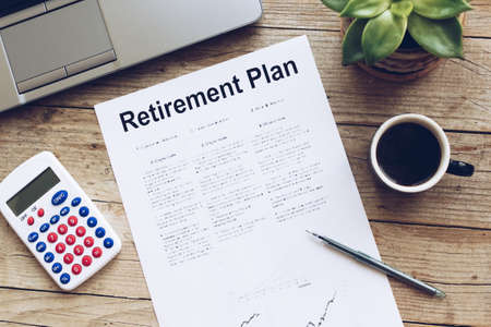 Retirement Plan. Calculator, pen, cup of coffee and notebook on wooden table. Business, finance,...