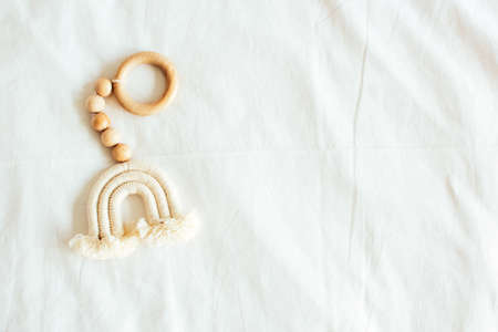 Baby wooden toy teethe eco natural. Scandinavian nomadic style rainbow toy on white linen...