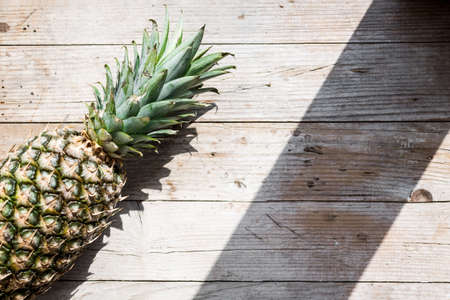 Ripe pineapple on a wooden background.の写真素材