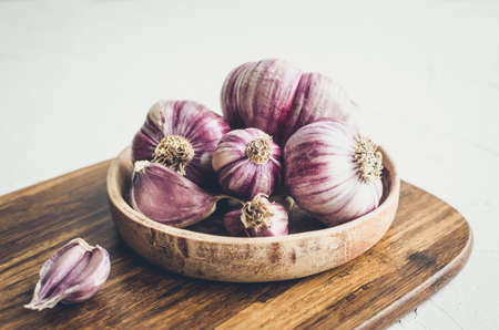 Rustic style garlic on vintage wooden background. Fresh young peeled purple garlic.の写真素材