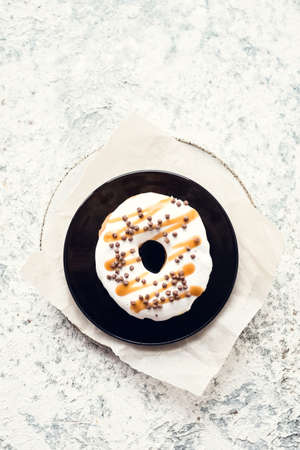 Plate with donut over light background. Top view. Copy space.の写真素材