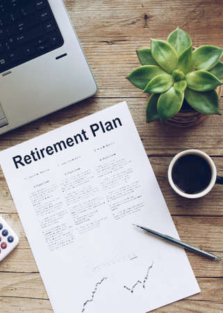 Retirement Plan. Calculator, pen, cup of coffee and notebook on wooden table. Business, finance,...